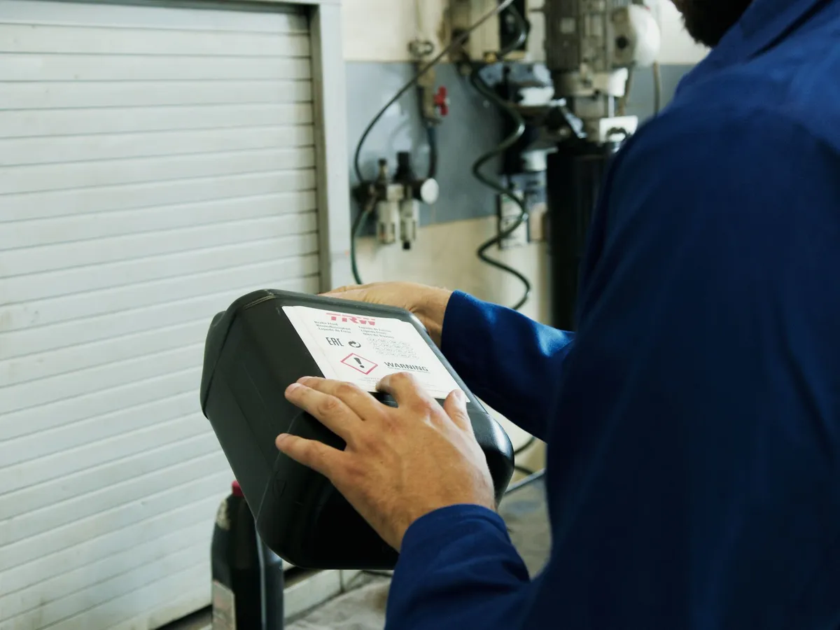 Manos de un mecánico usando la tablet del equipo de diagnosis electrónica
